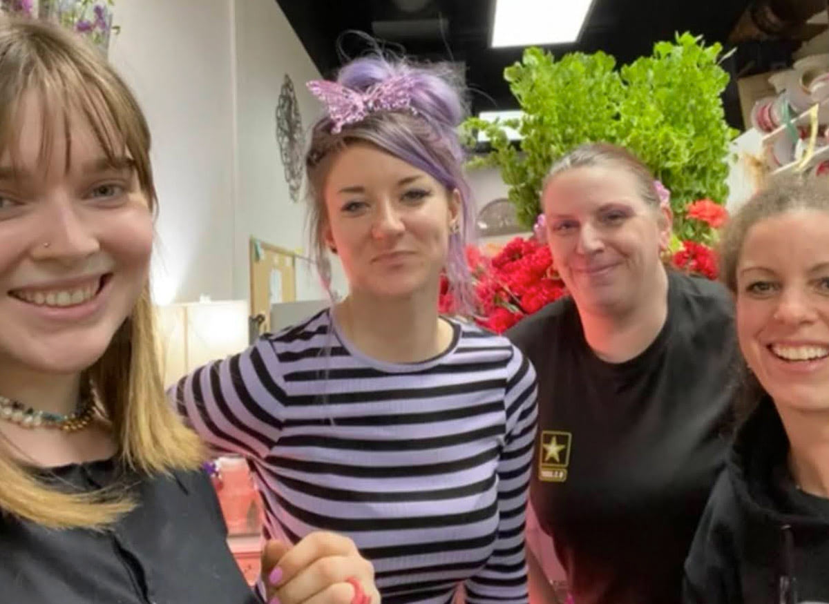 Four Wishing Well staff members share a smile together behind the counter